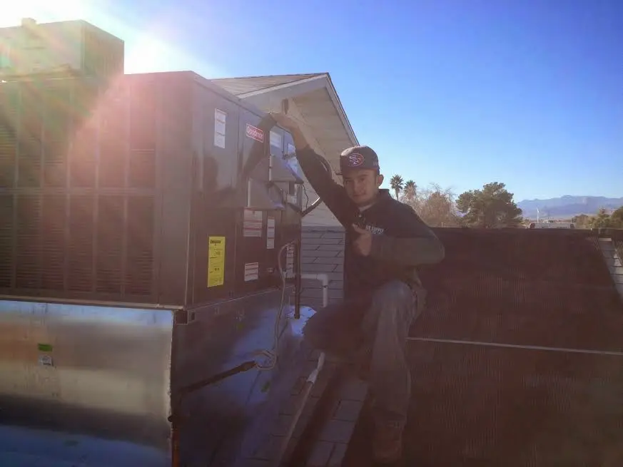 HVAC technician performing AC Tune-Up on a rooftop unit in Glenvar Heights